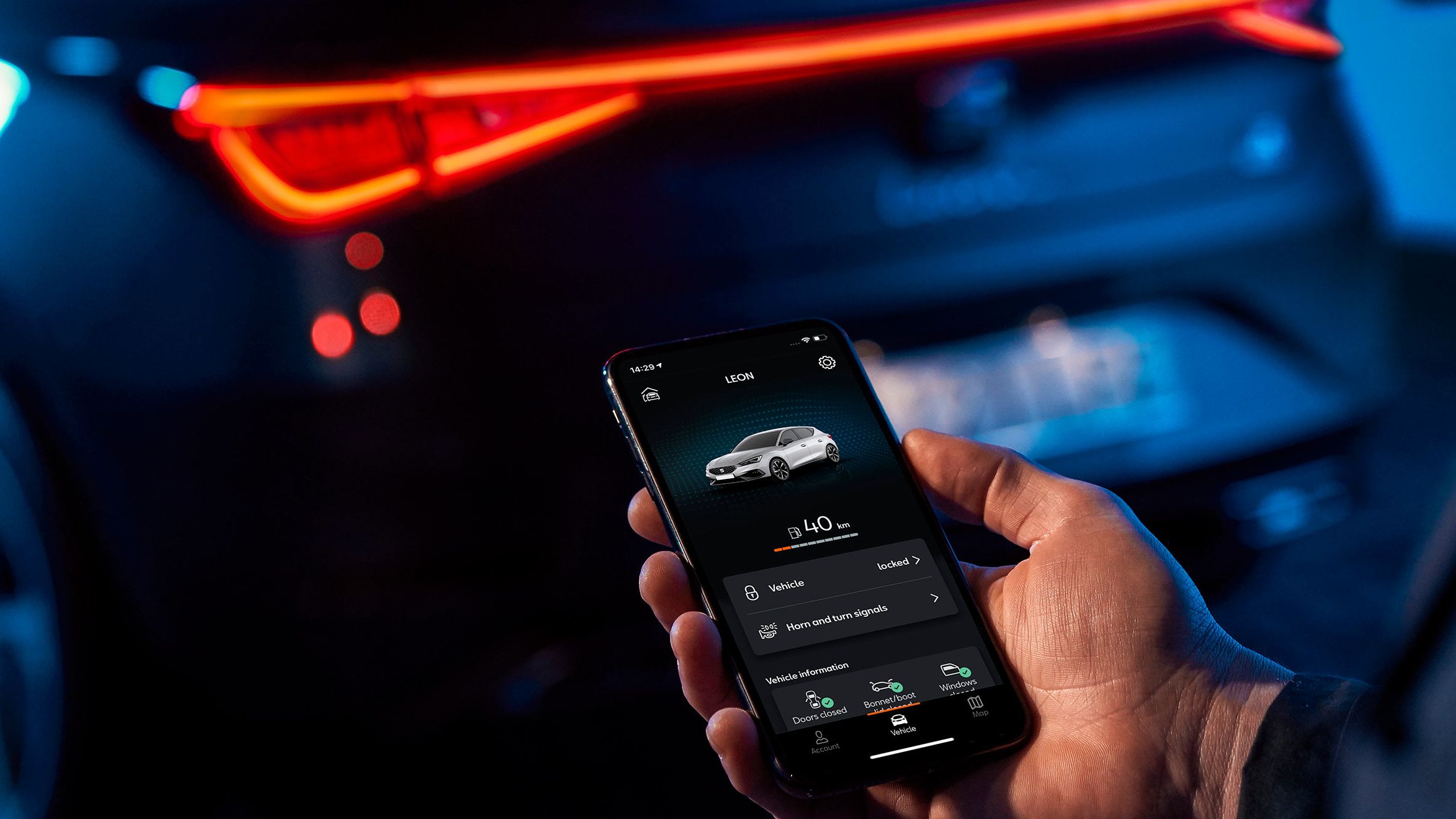 Ein Mann ruft über eine App die aktuelle Reichweite seines SEAT Leon ab