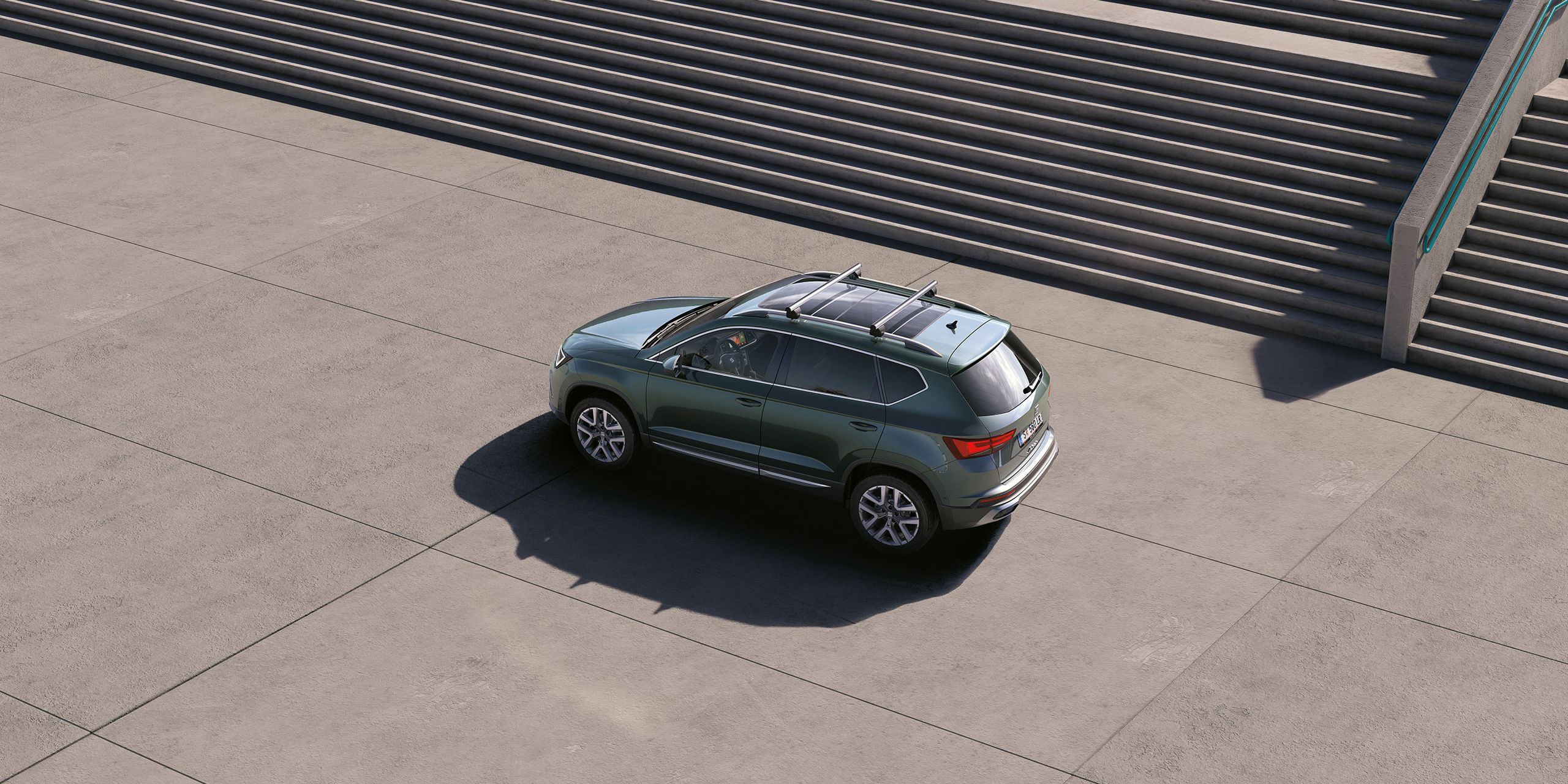 Ein grüner SEAT Ateca mit Dachträger.