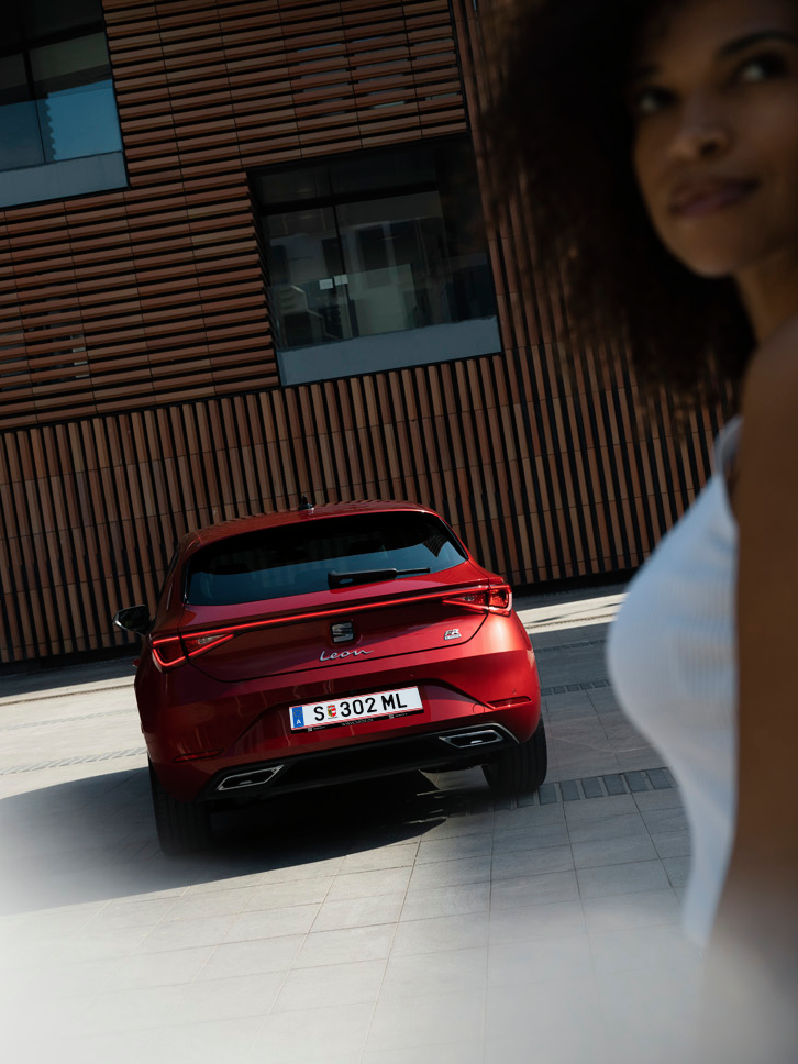 Frau steht vor dem SEAT Leon