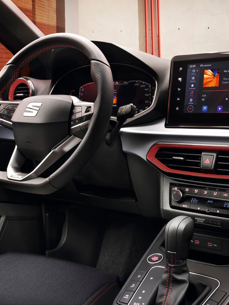 Innenansicht mit Fokus auf das Lenkrad, das digitale Cockpit und das Display, das gerade Musik abspielt