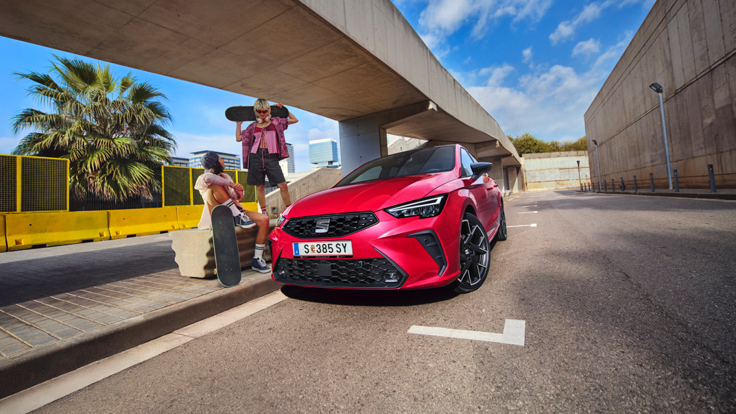 SEAT Ibiza unter Unterführung geparkt mit zwei Personen mit Skateboards neben Auto