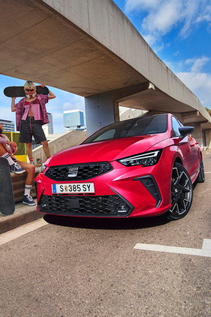 SEAT Ibiza unter Unterführung geparkt mit zwei Personen mit Skateboards neben Auto