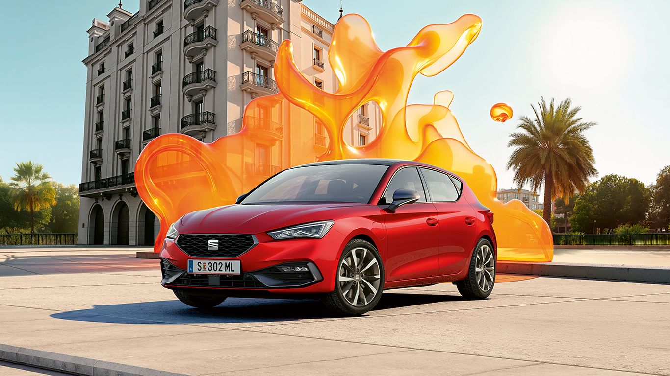 Schräge Frontansicht eines roten SEAT Leon vor einem historischen Gebäude.