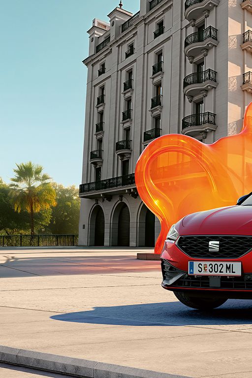 Schräge Frontansicht eines roten SEAT Leon vor einem historischen Gebäude.