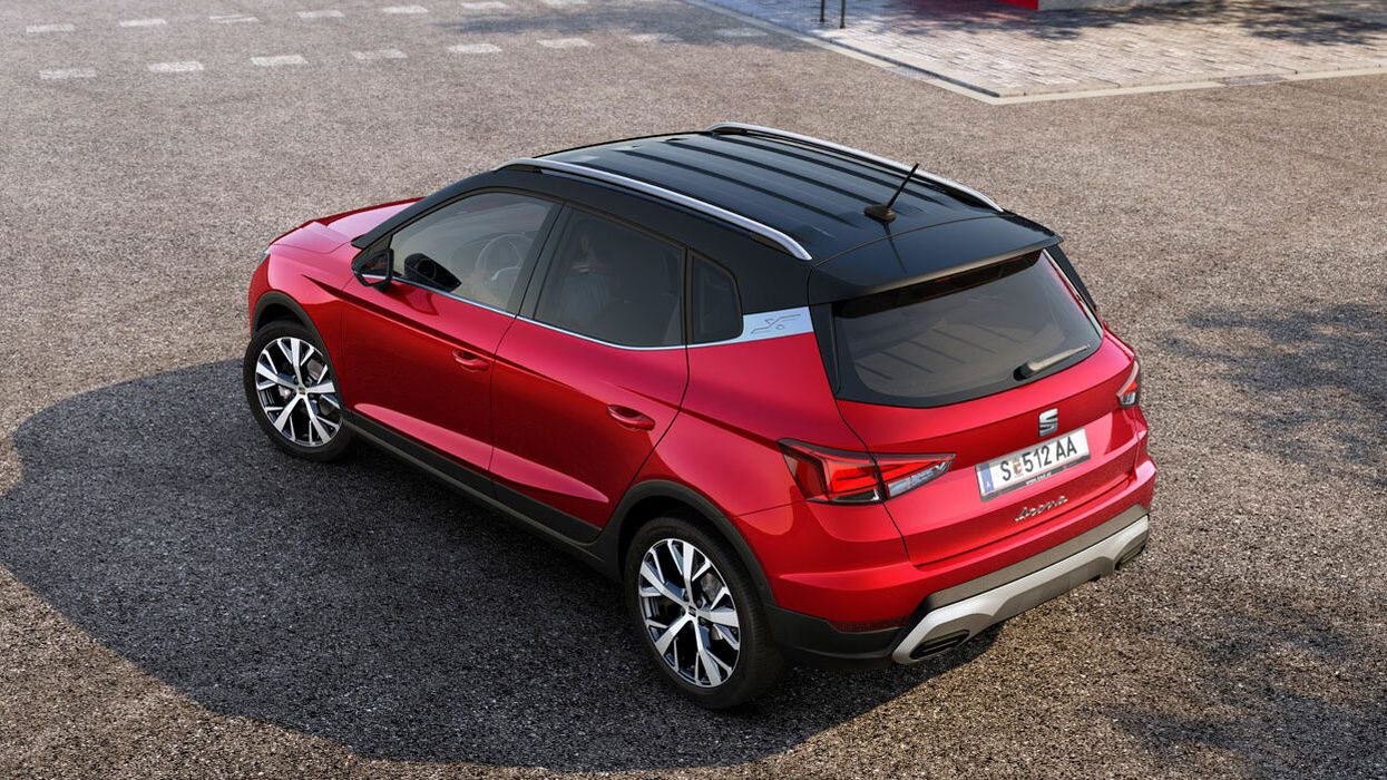 Ein SEAT Arona in rot in seitlicher Heckansicht.