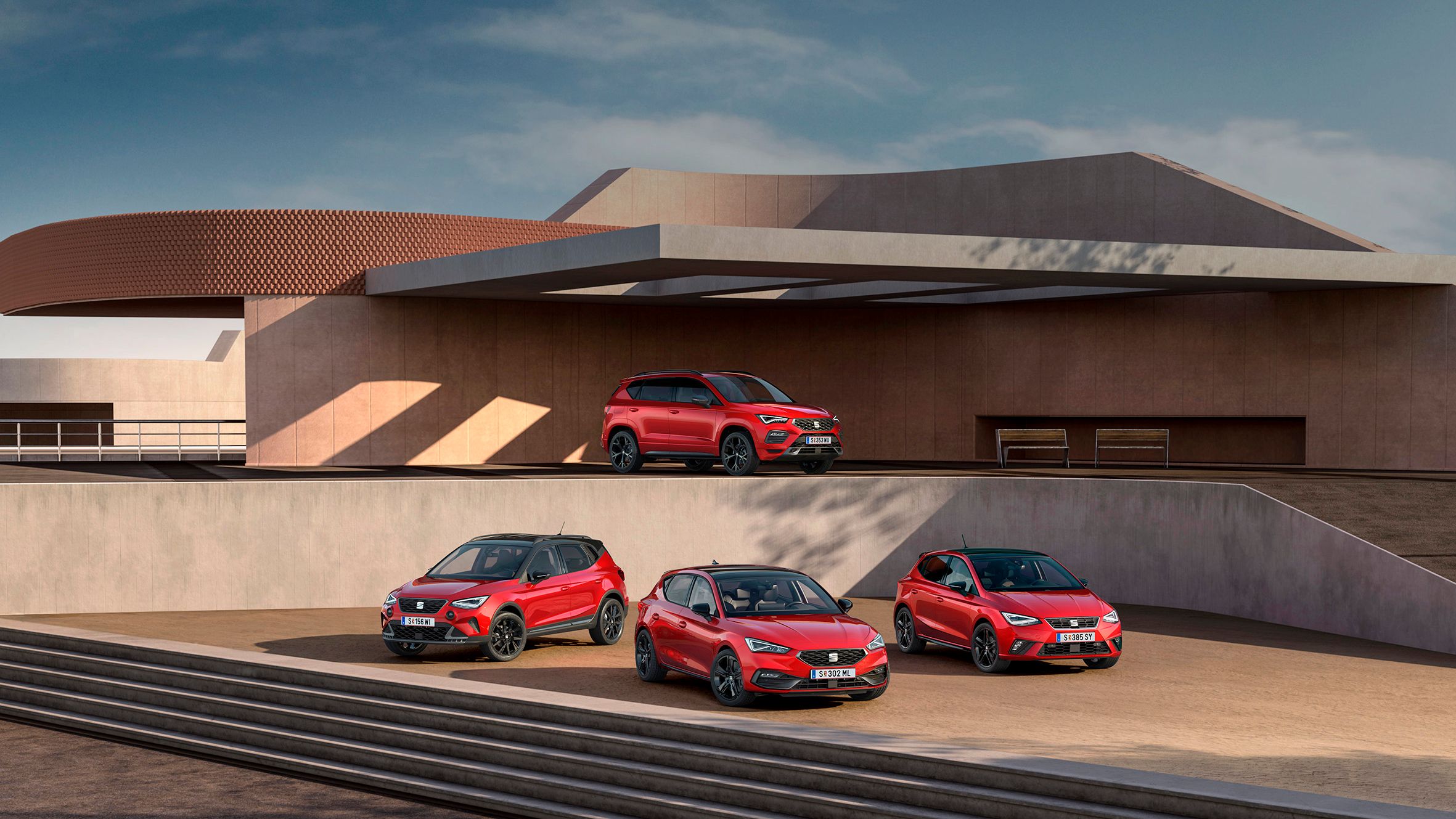 SEAT Black Edition Range shooting, sind vor einem zweistöckigen öffentlichen Gebäude mehrere Modelle zu sehen: Im unteren Bereich stehen der Arona, der Leon und der Ibiza, während auf der oberen Etage der Ateca positioniert ist