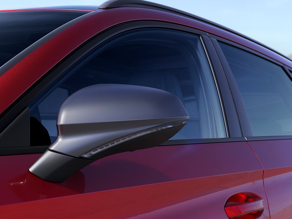 Detailansicht der Cosmo Grey Spiegelkappen bei einem SEAT Leon SP Kombi in Desire Red.