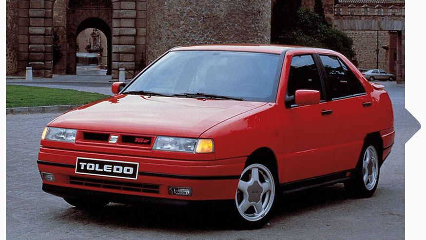 Ein roter SEAT Toledo von 1991 in Fahrt durch eine Stadt.