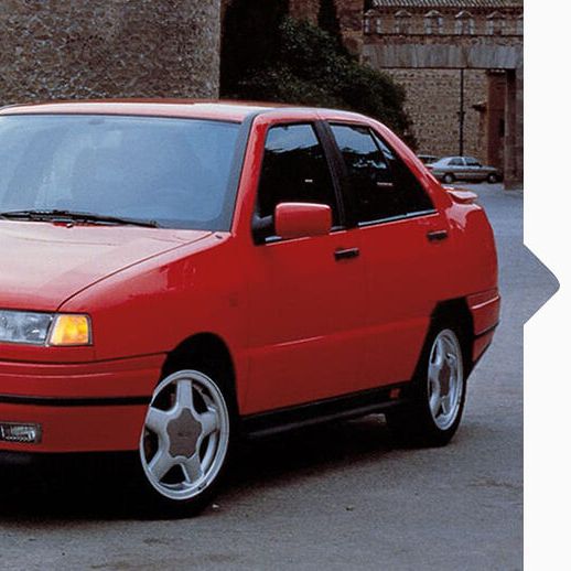 Ein roter SEAT Toledo von 1991 in Fahrt durch eine Stadt.