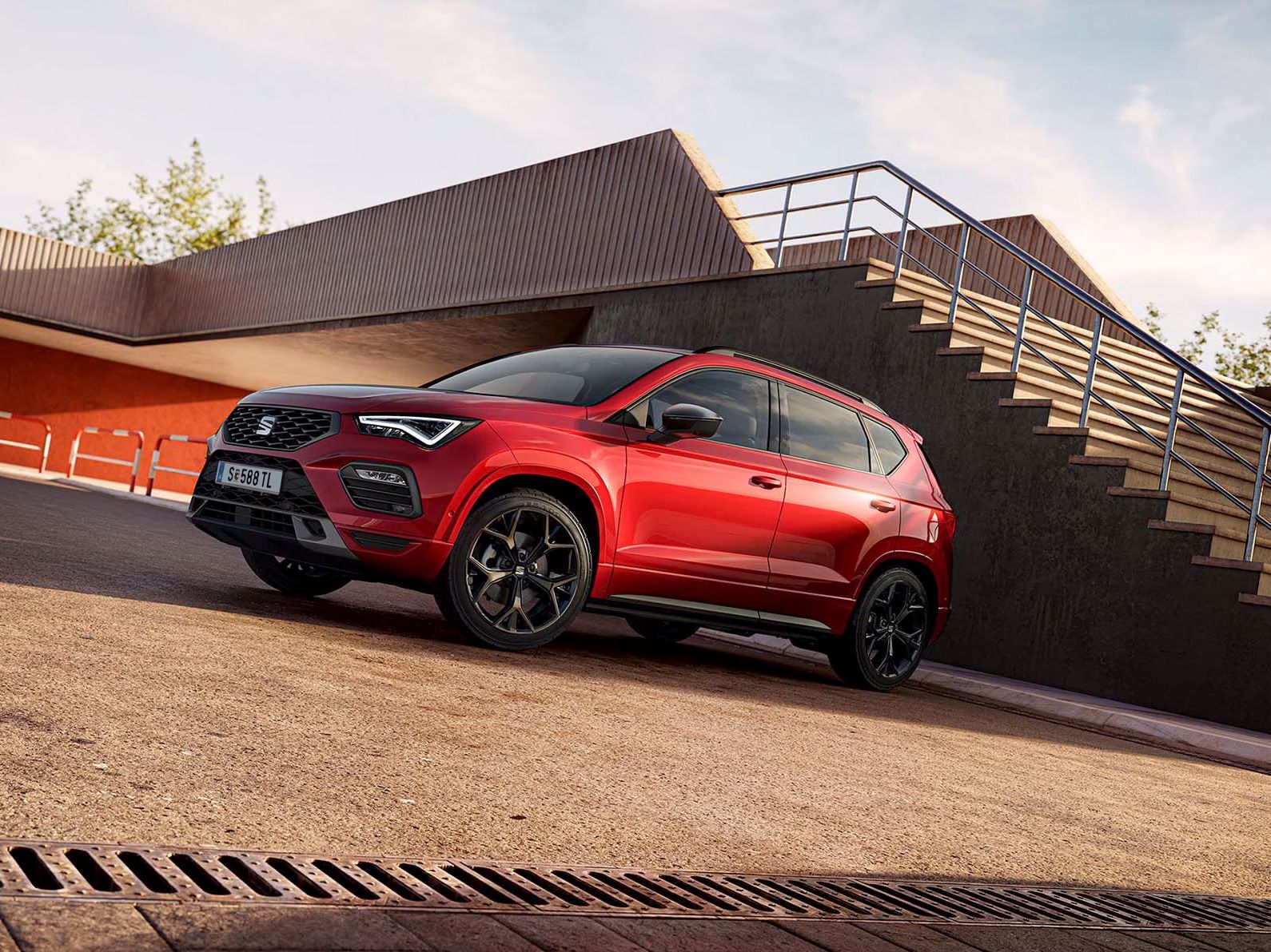 Ein SEAT Ateca in der Black Edition mit roter Lackierung steht perspektivisch aufgenommen auf einem Parkplatz