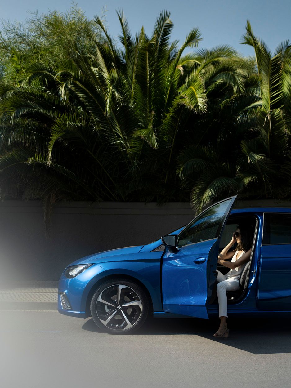 Eine Frau streckt ihren Fuß aus einem blauen SEAT Ibiza.