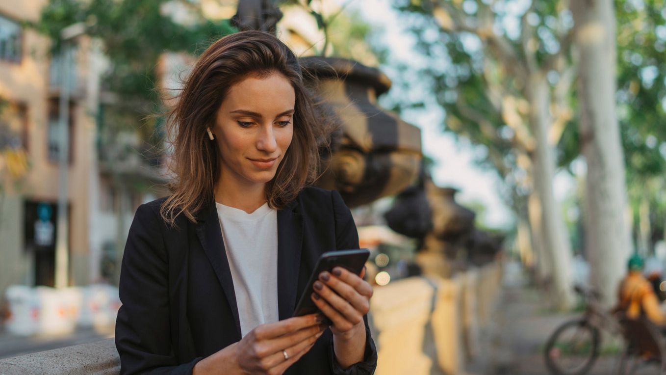 Frau nutzt ihr Smartphone für SEAT CONNECT.