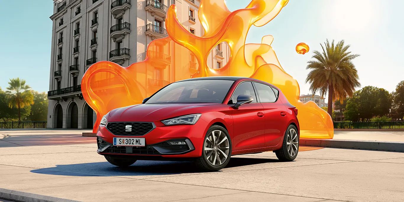 Schräge Frontansicht eines roten SEAT Leon vor einem historischen Gebäude.