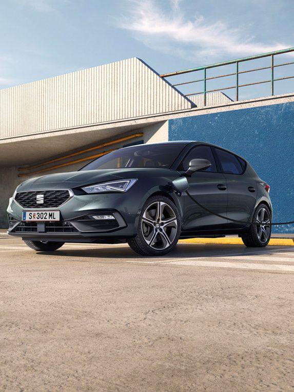 Ein SEAT Leon 5-Türer e-Hybrid steht an der Ladesäule und wird geladen.