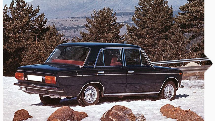 Ein schwarzer SEAT 124 aus den Jahr 1964 parkt im Schnee an einer Bergstraße.