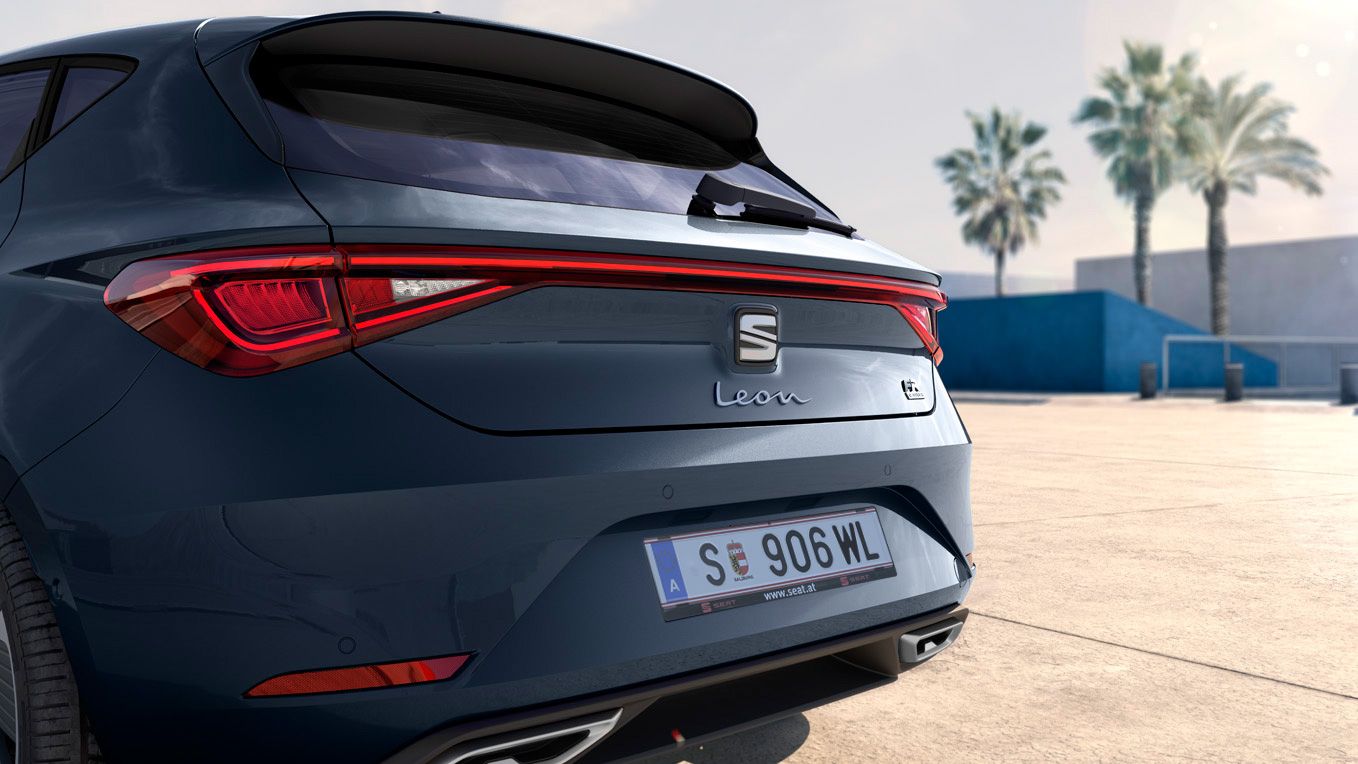 Detailansicht des Hecks von einem grauen SEAT Leon. Im Hintergrund sind Palmen zu sehen.