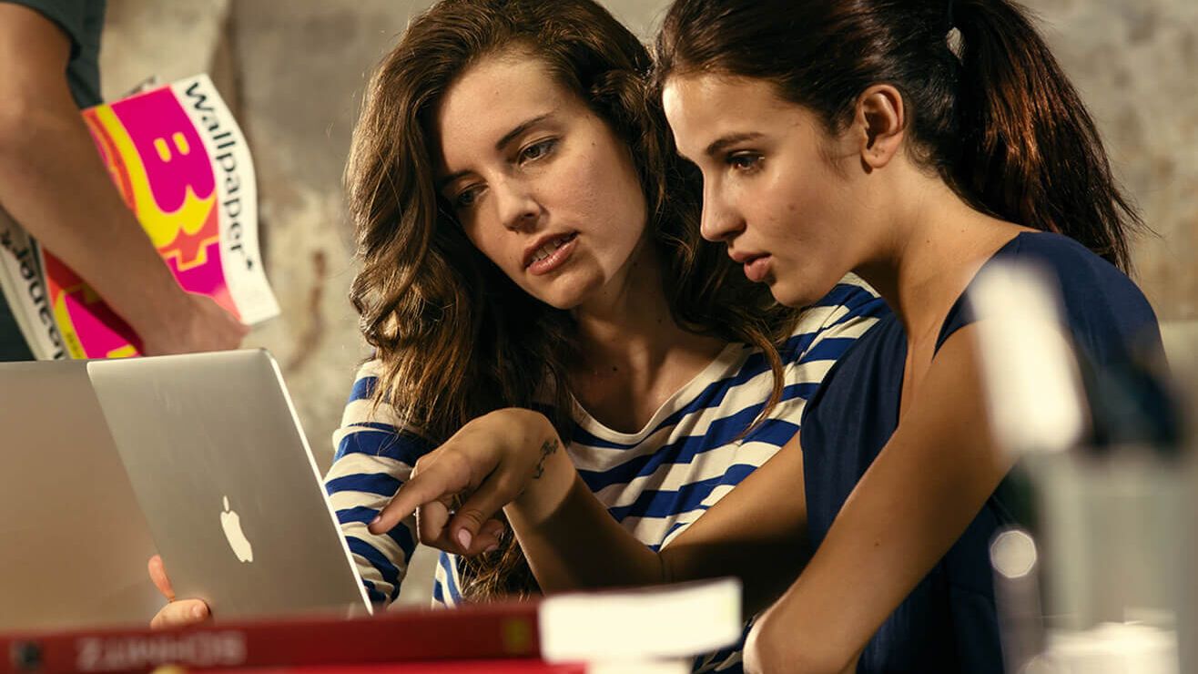 Zwei Frauen schauen sich auf einen Laptop was gemeinsam an