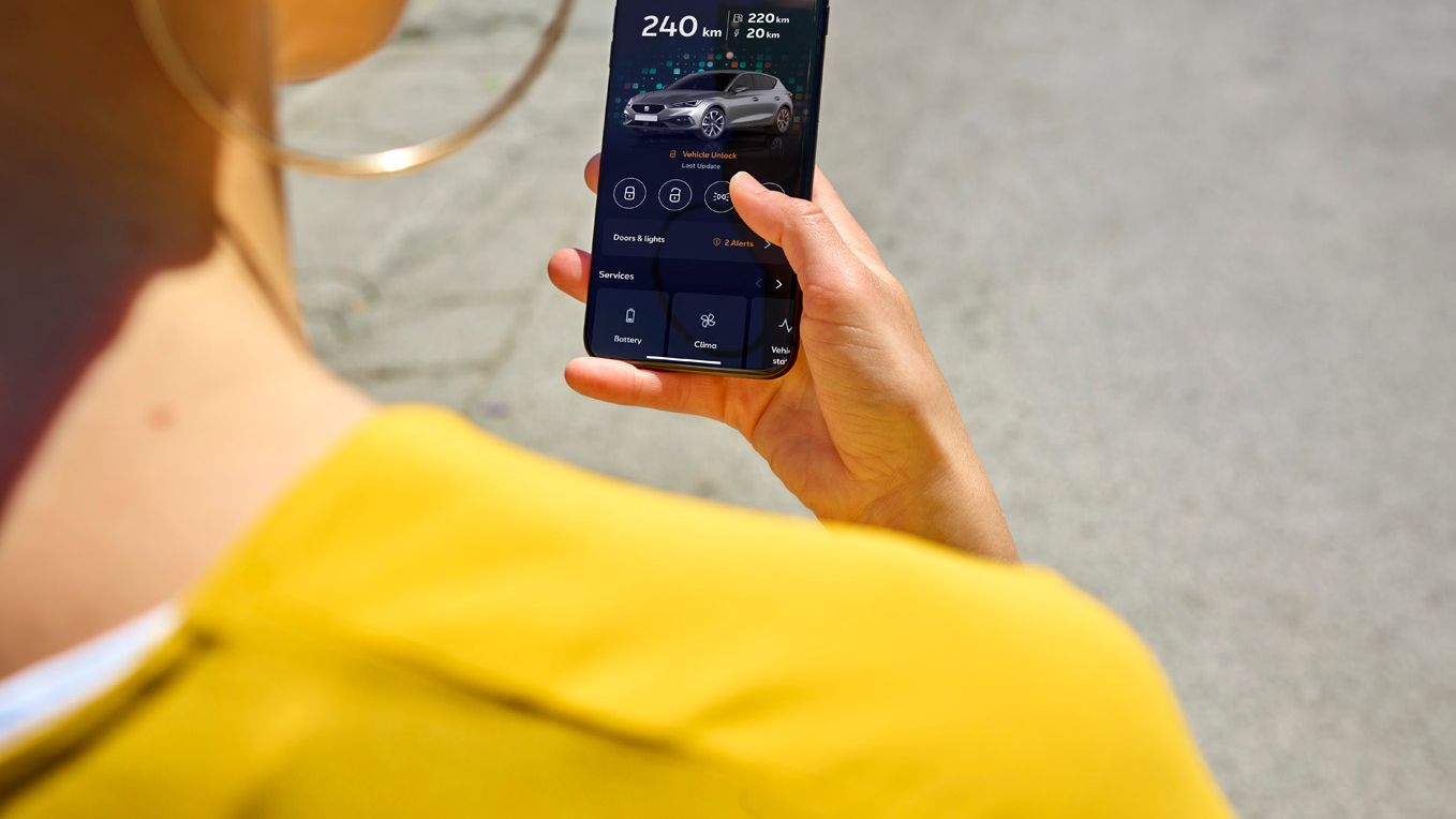 Frau hält Smartphone in der Hand, welches die My SEAT App zeigt