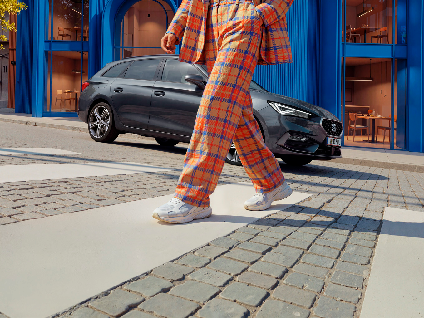 Ein bunt gekleideter Mann läuft von seinem SEAT Leon NF weg