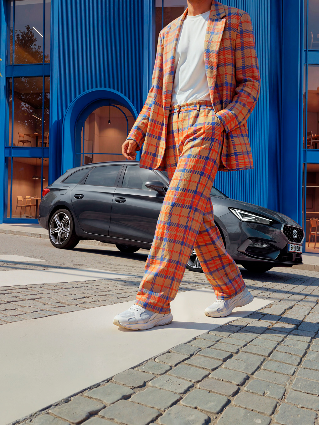 Ein bunt gekleideter Mann läuft von seinem SEAT Leon NF weg