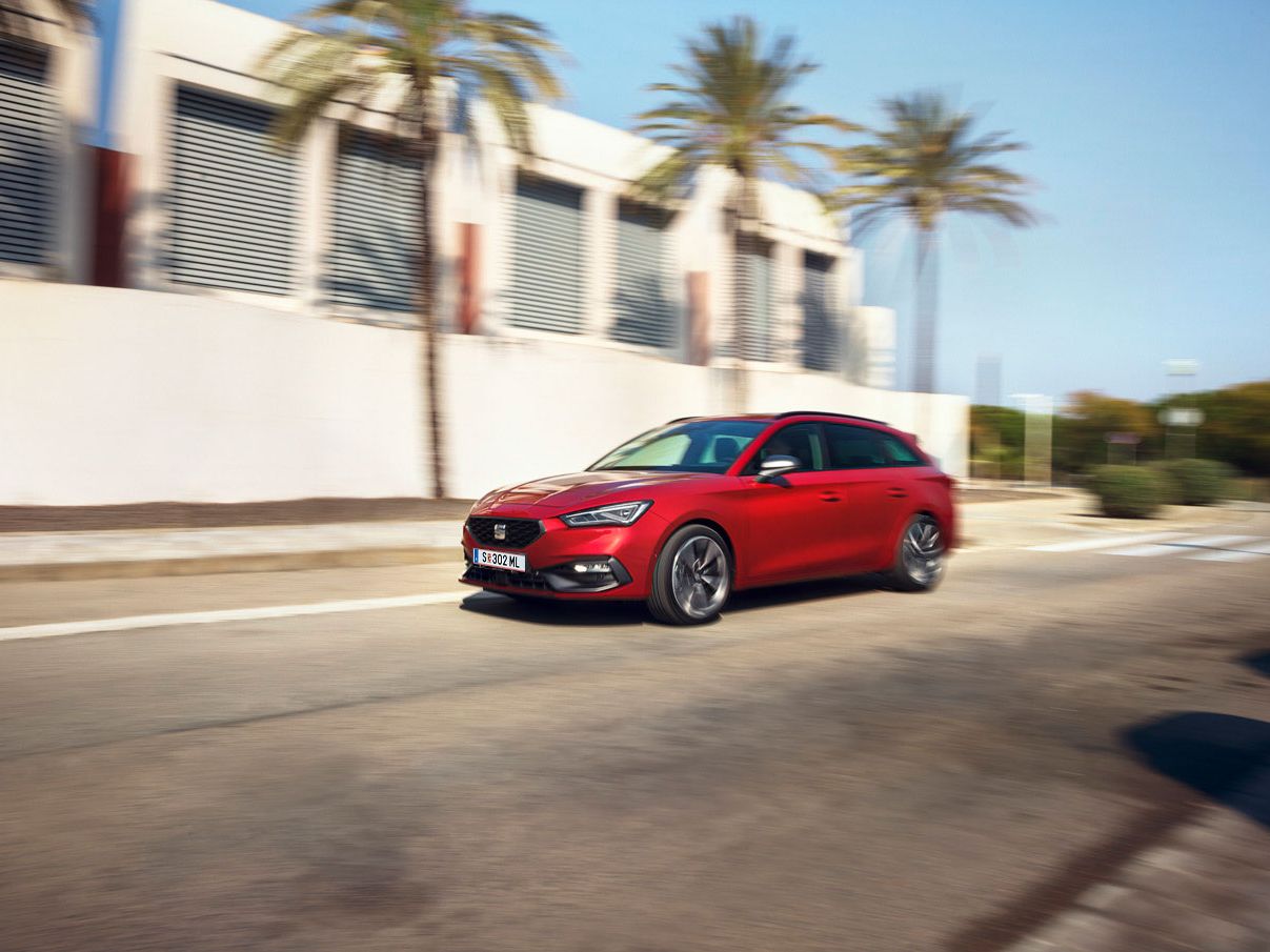 Dynamische Fahraufnahme eines roten SEAT Leon SP Kombi in städtischer Umgebung