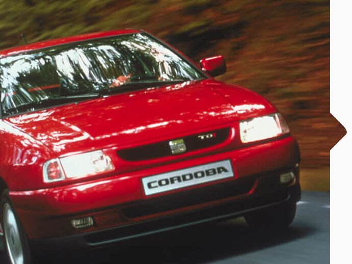 Ein roter SEAT Cordoba von 1993 in Fahrt.