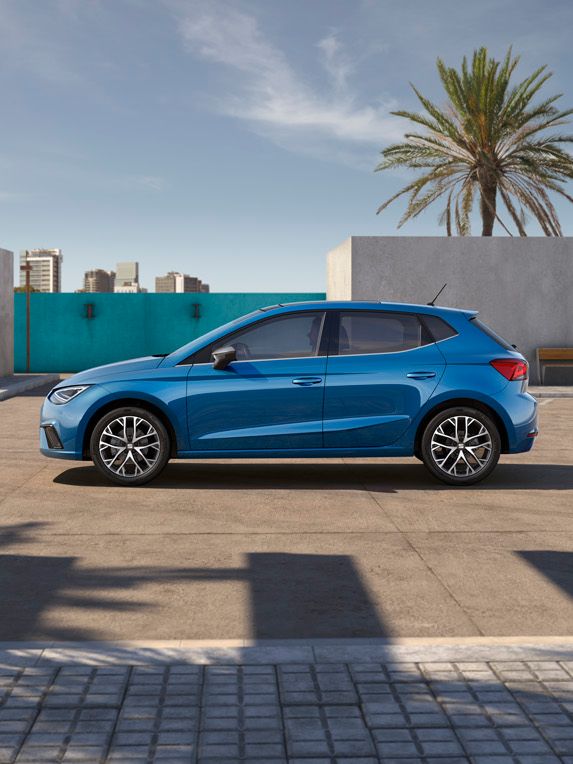 Ein blauer SEAT Ibiza präsentiert sich in seitlicher Ansicht, geparkt auf einem Parkplatz.