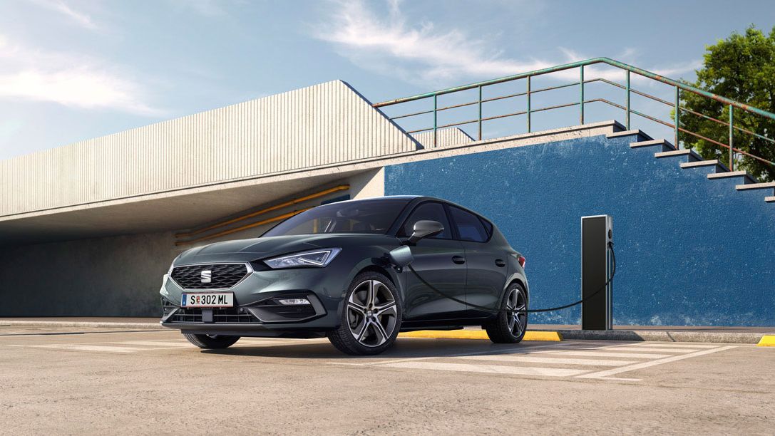 Ein SEAT Leon 5-Türer e-Hybrid steht an der Ladesäule und wird geladen.