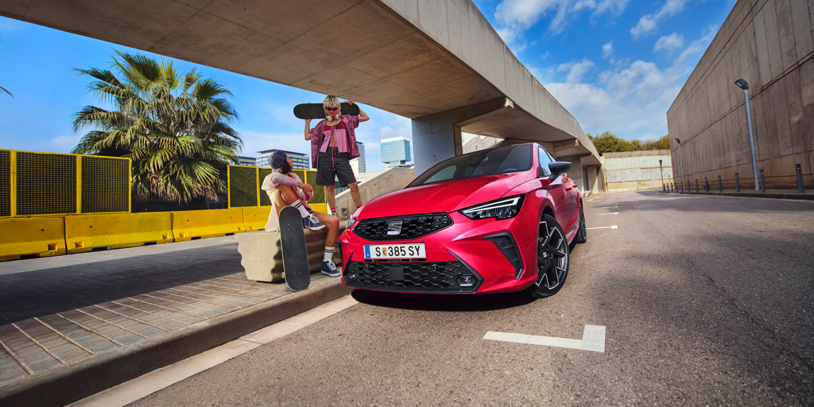 SEAT Ibiza unter Unterführung geparkt mit zwei Personen mit Skateboards neben Auto