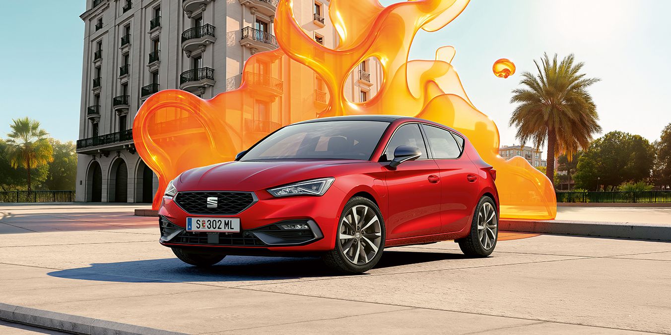 Schräge Frontansicht eines roten SEAT Leon vor einem historischen Gebäude.