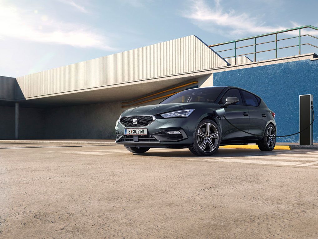 Ein SEAT Leon 5-Türer e-Hybrid steht an der Ladesäule und wird geladen.