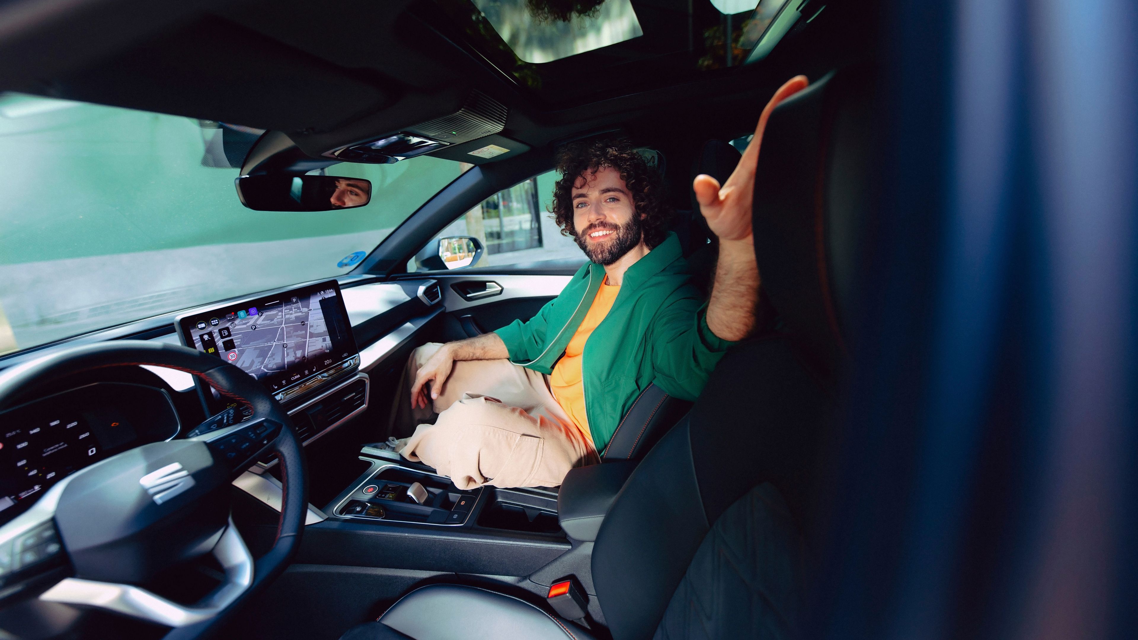 Mann sitzt am Beifahrersitz im SEAT Leon mit Navigation am Screen