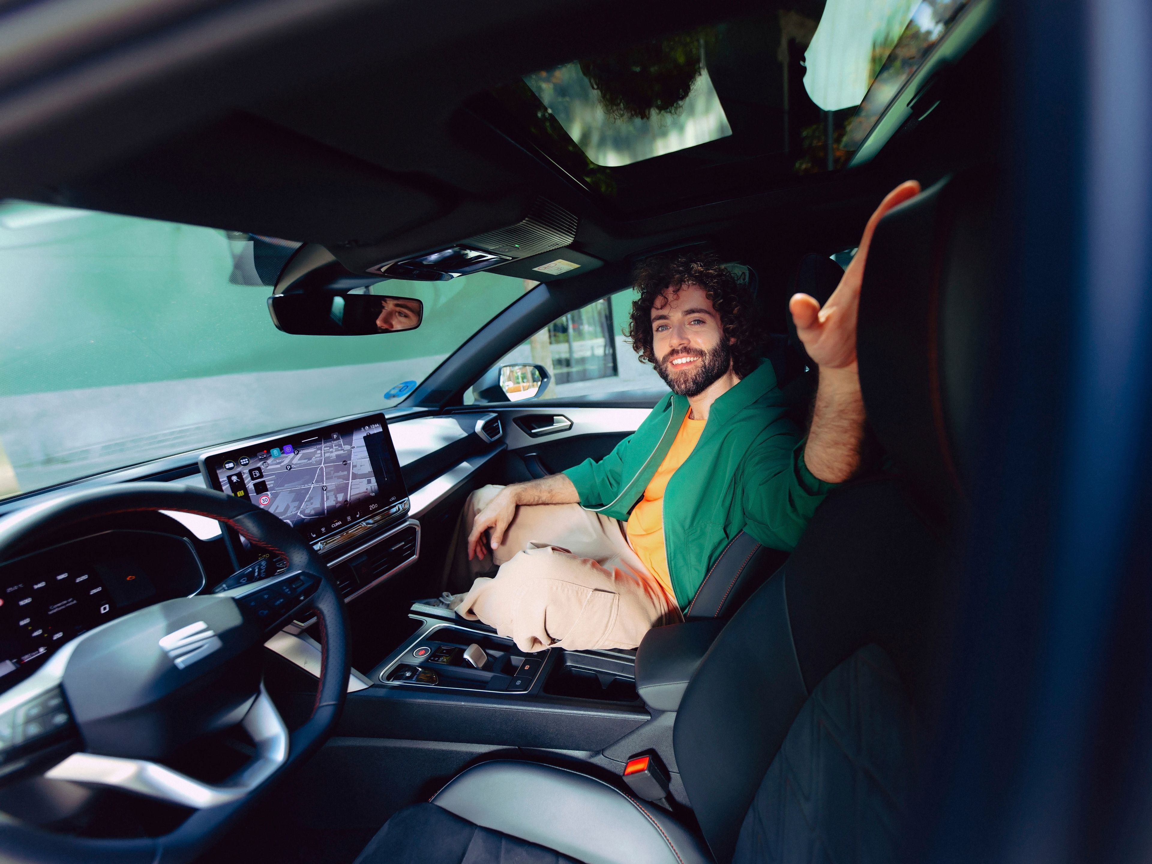 Mann sitzt am Beifahrersitz im SEAT Leon mit Navigation am Screen