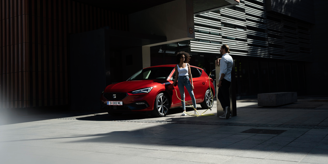 zwei Menschen neben dem Auto beim Laden 