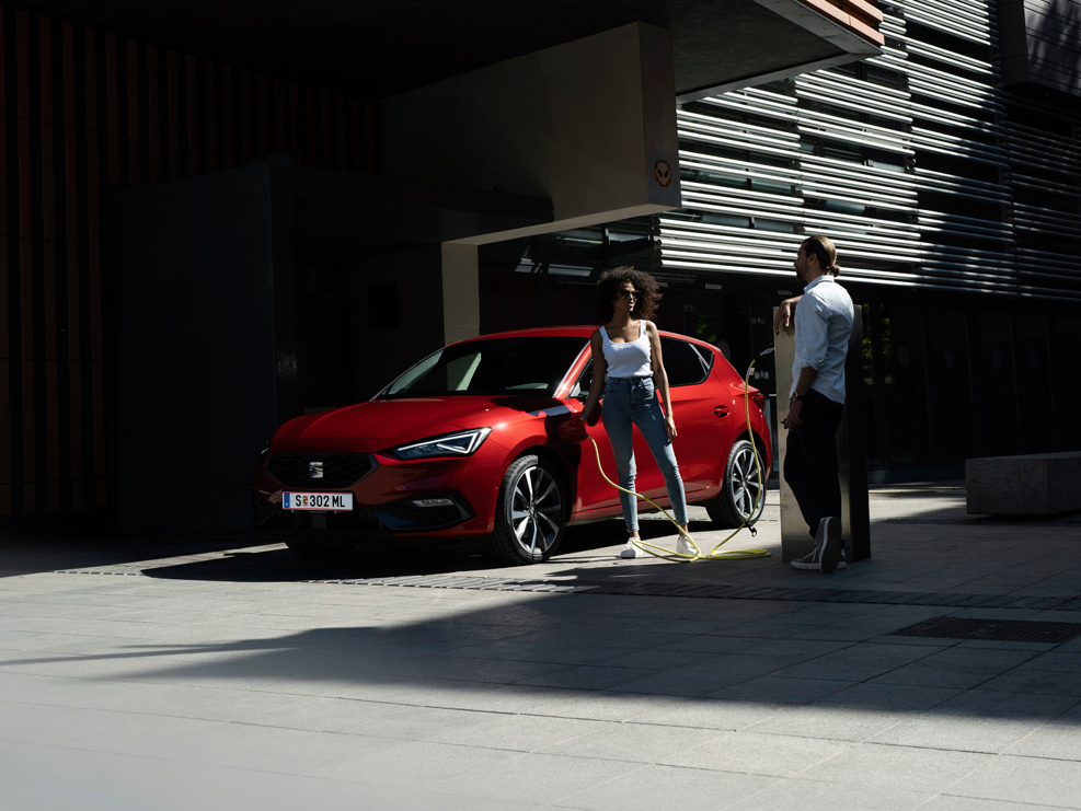 zwei Menschen neben dem Auto beim Laden 