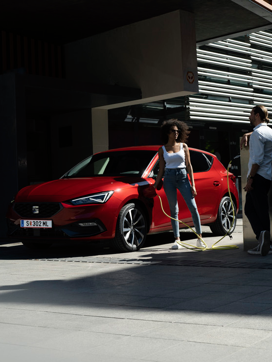 zwei Menschen neben dem Auto beim Laden 
