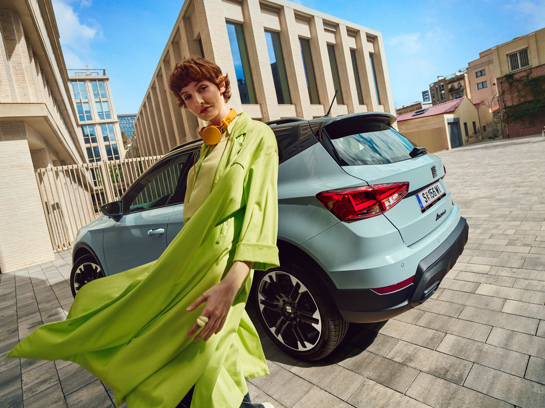 Frau in grünem Outfit vor dem SEAT Arona