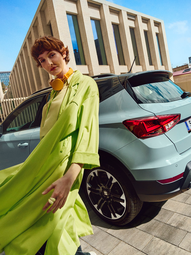 Frau in grünem Outfit vor dem SEAT Arona
