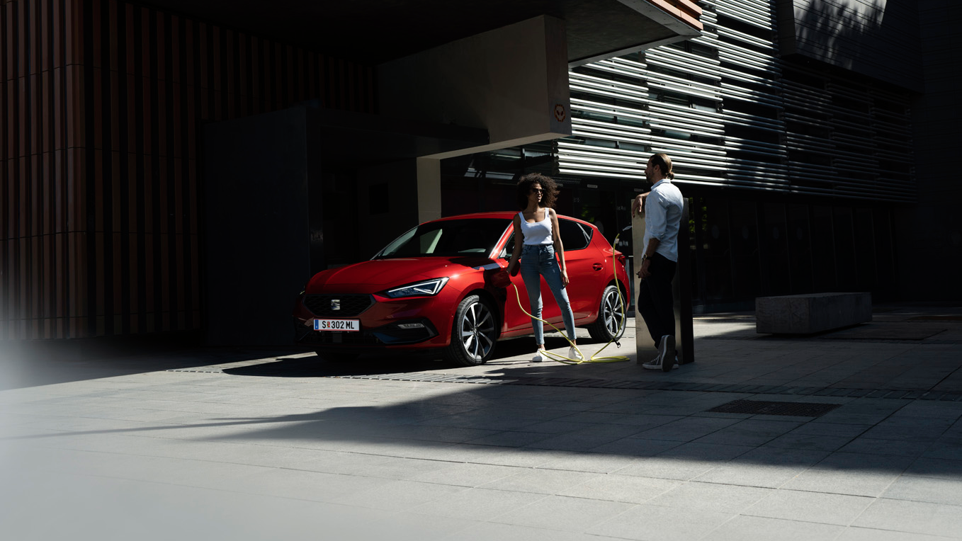 zwei Menschen neben dem Auto beim Laden 