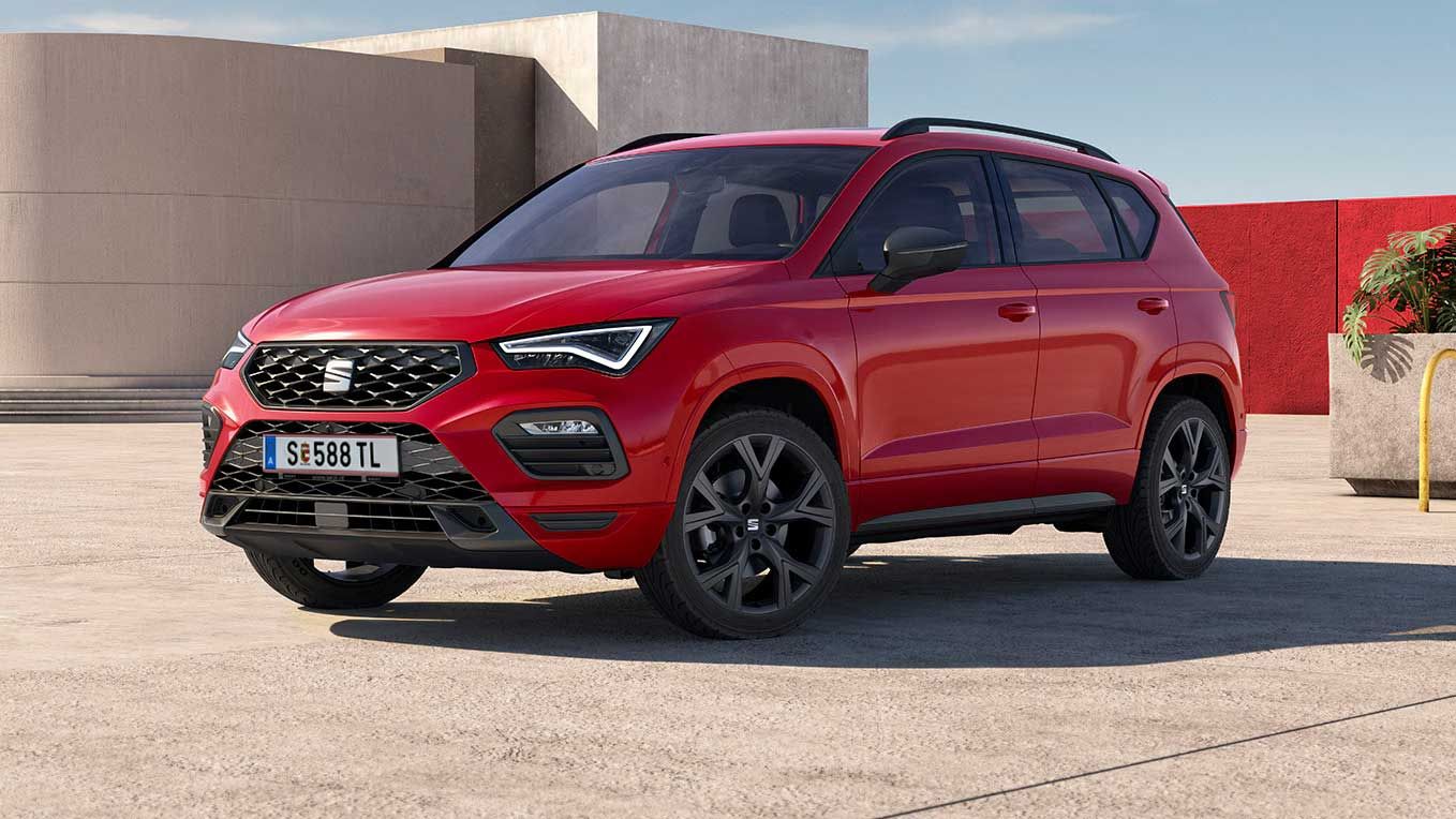 Ein roter SEAT Ateca steht auf einem Platz vor einer roten Mauer.
