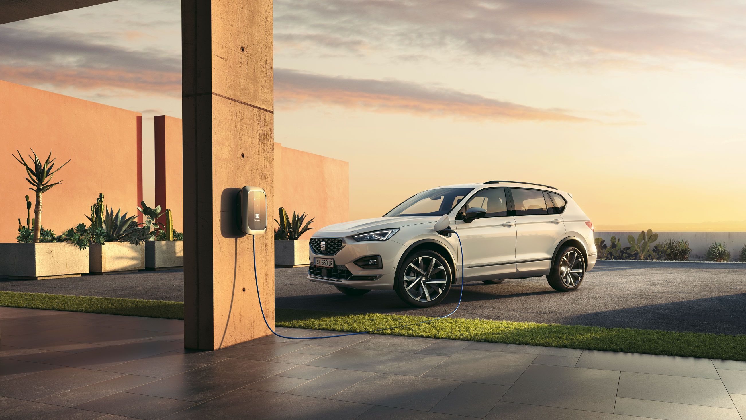 Ein weißer SEAT Tarraco e-Hybrid beim Ladevorgang.
