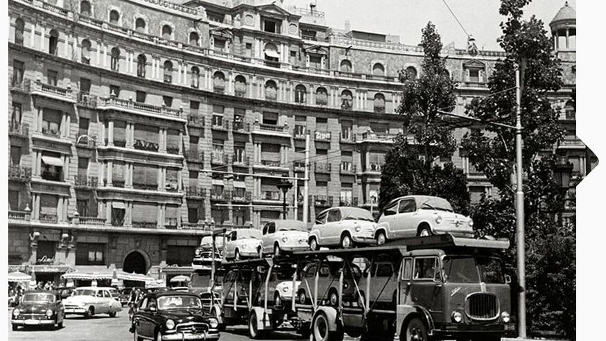 Schwarz weiß Aufnahme von 1950 mit einem LKW der mit den ersten SEAT Modellen beladen ist.