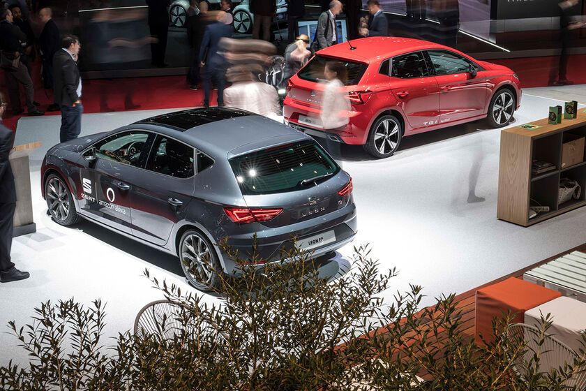 Messestand mit Präsentation von einem grauen SEAT Leon und einem roten SEAT Ibiza. 